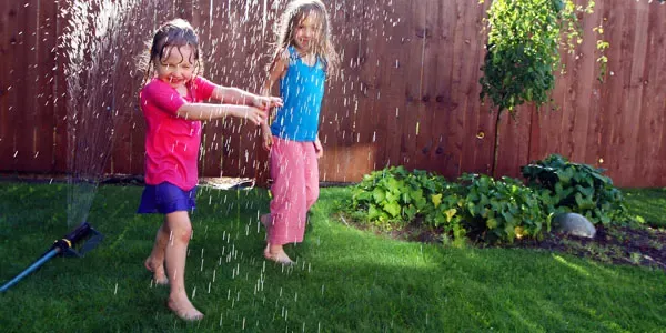 Kids playing outside on green healthy lawn
